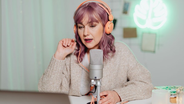 A woman podcasts with headphones on