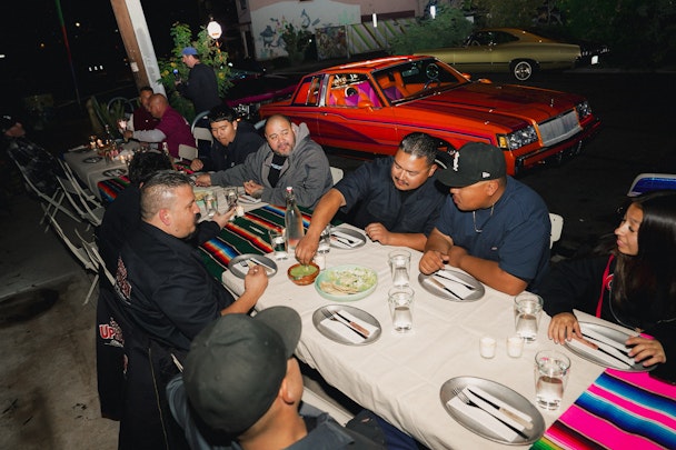 Men from the Lowride community sitting at a dinner table 