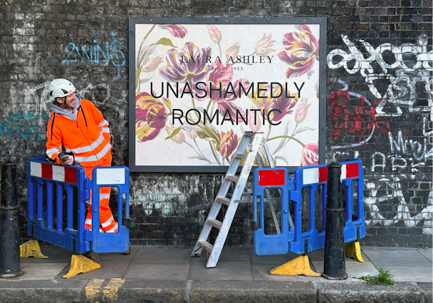 Poster for Laura Ashley with construction worker looking at it 