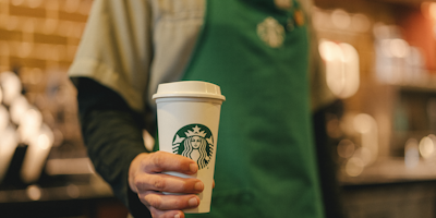 Starbucks barista holding a takeaway coffee