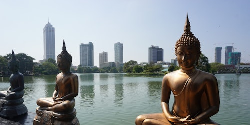 Images of Budhas in front of office towers in Sri Lanka