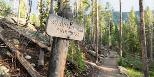 Sign urging hikers not to take a shortcut