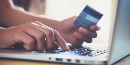 hand with credit card on the computer hand with credit card on the computer
