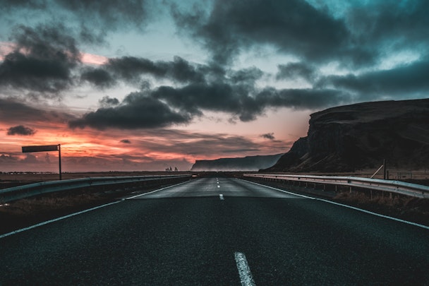 Long road underneath cloudy sky at sunset in Vik, Iceland