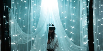 Woman using VR headset, surrounded by fairy lights