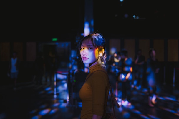 Asian woman in focus against dark background