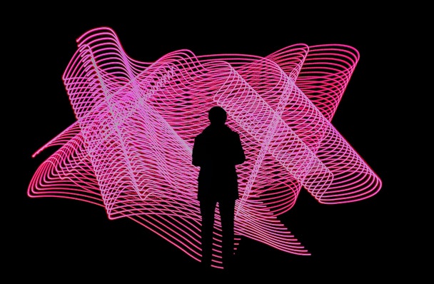 Silouhette of man stood in front of pink graphic design on black background