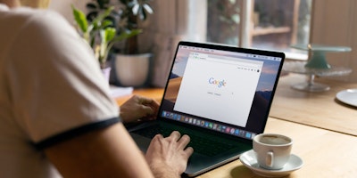 Man on laptop using Google Search