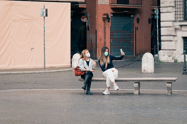 Women sat on a bench taking a selfie