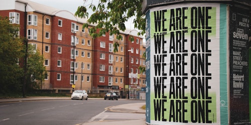 Poster on lamppost reads: 'We are one'