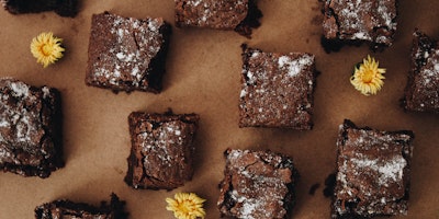 Brownies on parchment paper with scattered dandelions