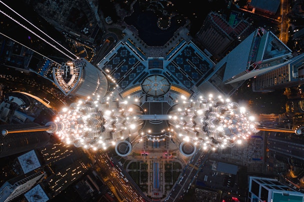 Aerial view of two identical lit-up skyscrapers 