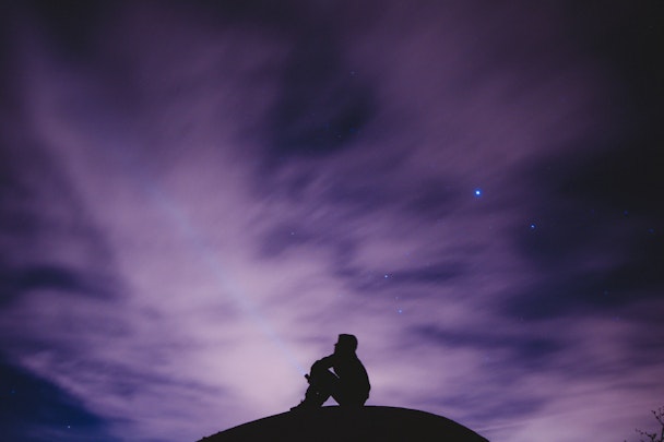 Man sat underneath starry night sky