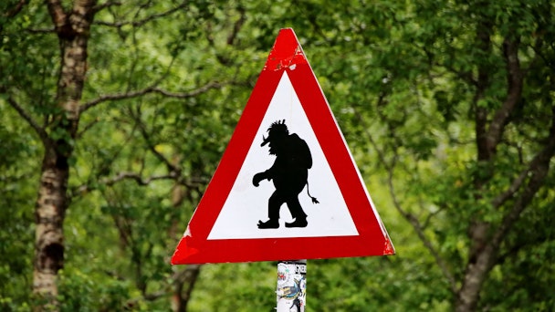 Troll crossing road sign