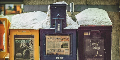 Free newspaper boxes covered in snow in Chinatown, Washington DC