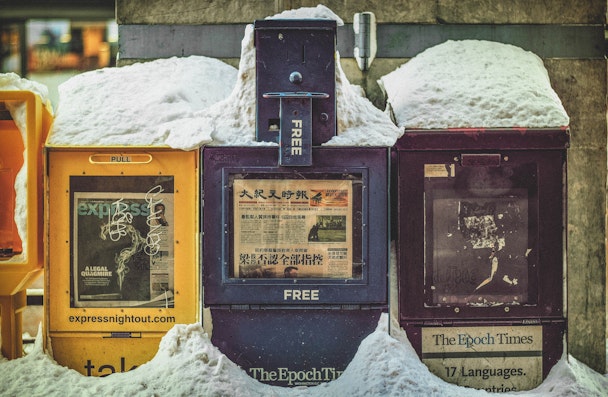 Free newspaper boxes covered in snow in Chinatown, Washington DC