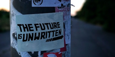 Sticker on lamppost: "the future is unwritten"