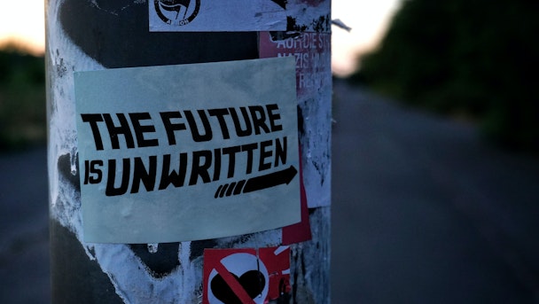 Sticker on lamppost: "the future is unwritten"