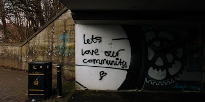 Alley way graffiti reads: 'let's love our community'