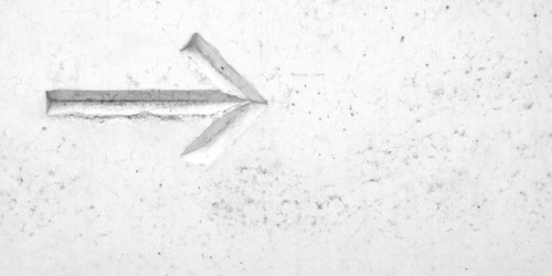 Right arrow embossed on white wall