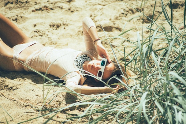 Woman lying in grass wearing 3D glasses