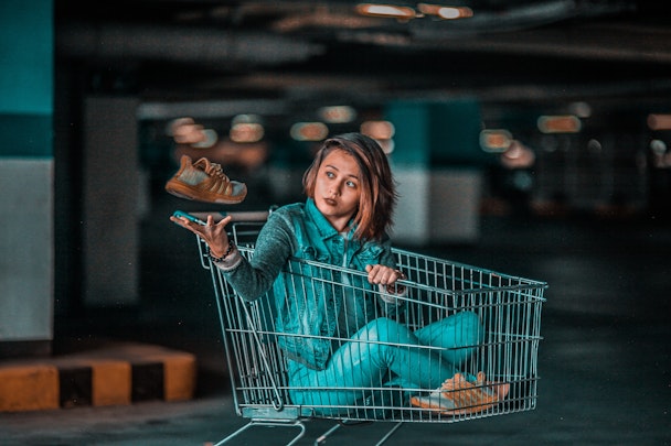 Woman sitting in shopping cart