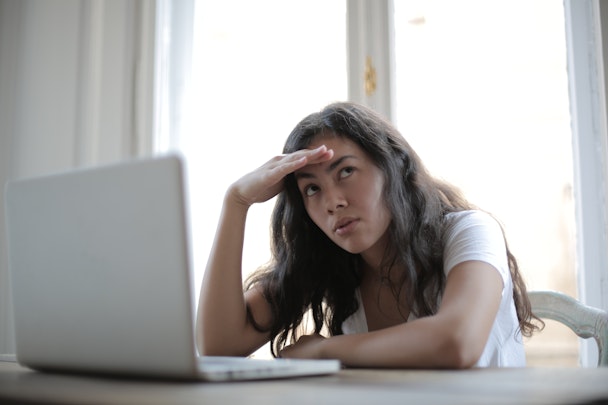 Woman at laptop deep in thought