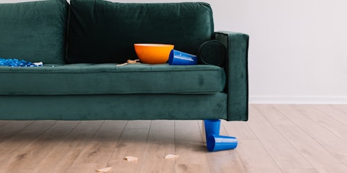 Blue velvet sofa with knocked over bowl of chips
