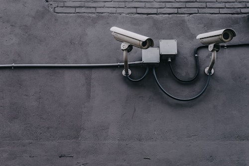 Monochrome image of CCTV cameras on wall