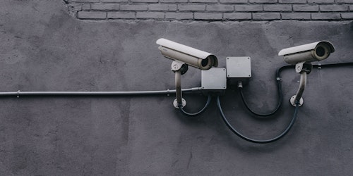 Monochrome image of CCTV cameras on wall