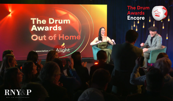 On stage at The Drum Awards for Out of Home, Rise New York & Partners is awarded. Cheering crowds are seen in the foreground as the winner is announced by excited hosts.