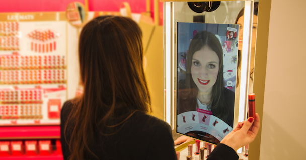 woman trying on lipstick in Coty's augmented reality mirror