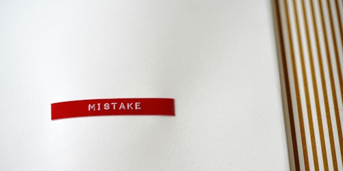 The word 'mistake' is printed in white on a red strip 
