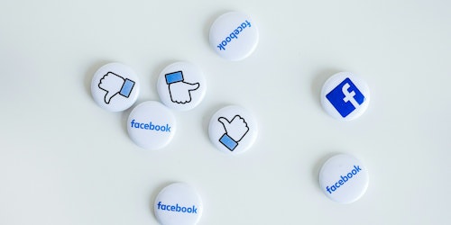 Facebook pin badges scattered on a white background