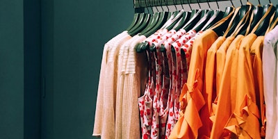 Red and orange clothes on a clothing rail