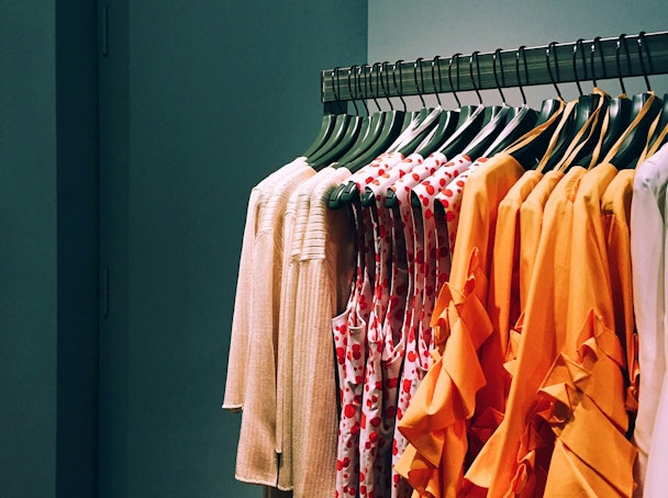 Red and orange clothes on a clothing rail
