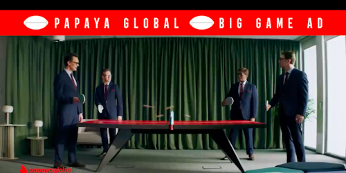 A still from Papaya Global's Super Bowl ad showing four men in business suits playing ping pong