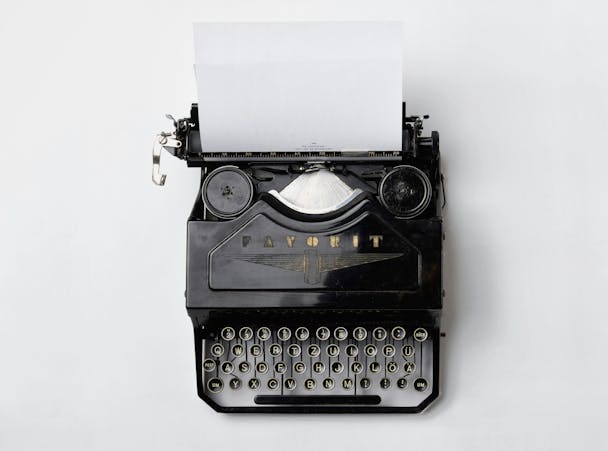 A black Fayorit typewriter against a white background