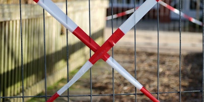 Red 'caution' tape over a gate