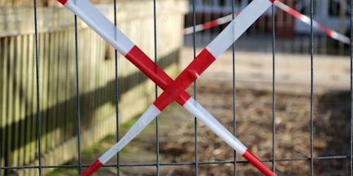 Red 'caution' tape over a gate