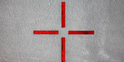 Four red lines mark a target on a grey wall