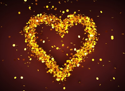 A golden heart shape made from gold discs against a red background 