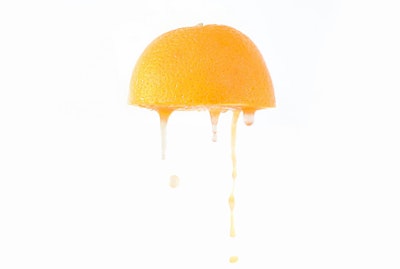 Juice drips from an orange half