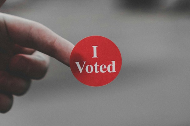 A sticker reading 'I voted' on the end of someone's finger 