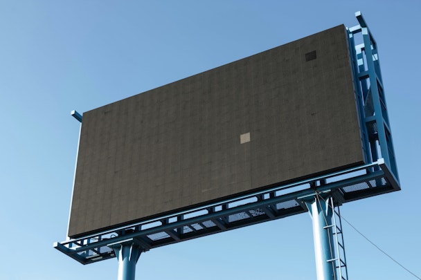 A blank digital billboard in front of a blue sky