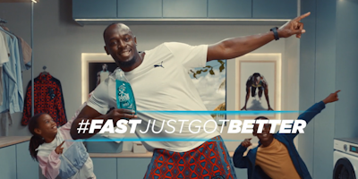 Usain Bolt doing a lightening bolt with two kids holding Persil washing detergent