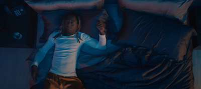 Lil Wayne lying on a bed