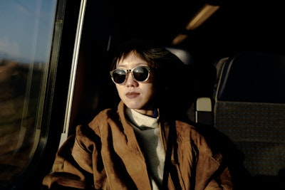 A young woman wearing sunglasses on a train