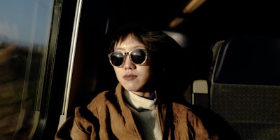 A young woman wearing sunglasses on a train