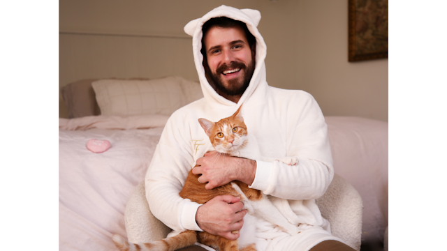man in cat sweater holding a cat